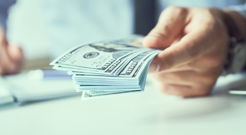 handing a stack of one hundred dollar bills