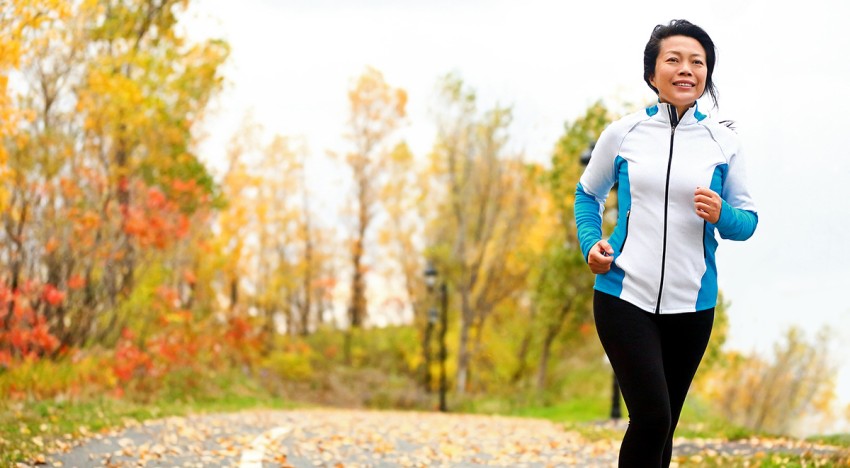 woman running outdoors with fall colors in the background